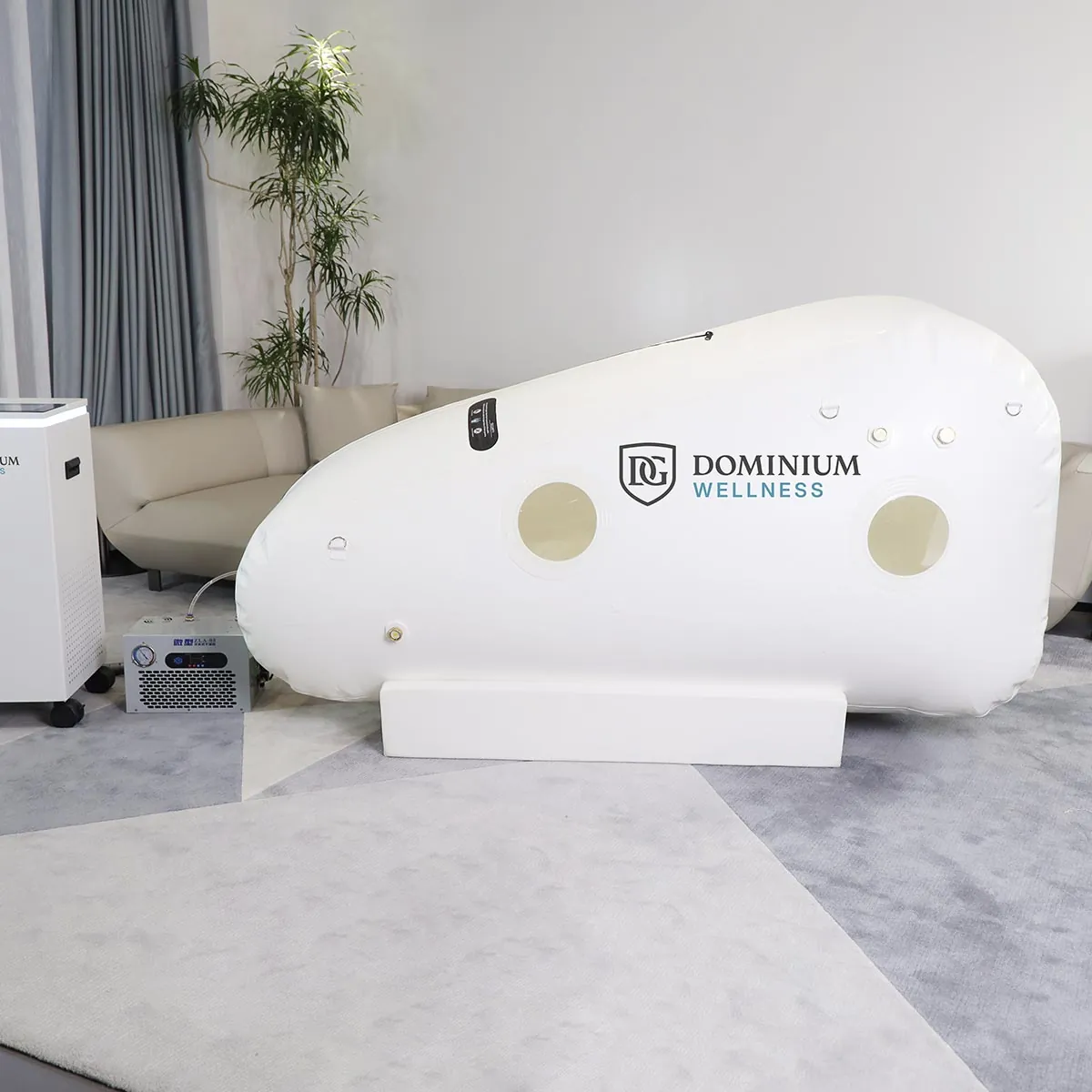 “Dominium Wellness” DW220MLS model beyaz hiperbarik kabinin bulunduğu ferah oda. Yakınındaki hava ekipmanı ve bitkiler sakin, klinik bir ambiyans yaratıyor.